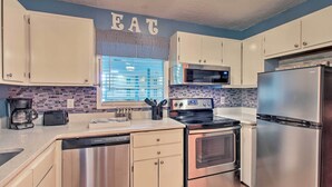 A modern kitchen with stainless steel appliances, white cabinets, and a blue accent wall. - Long-Term Stays Welcome: HH Island Resort Condo (Hilton Head)