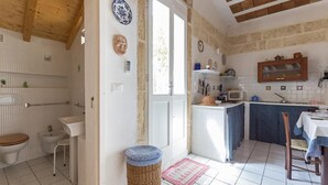 Una cocina compacta con lavamanos, microondas y armarios de madera.