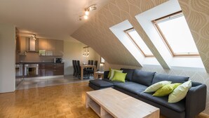 A modern loft apartment with a kitchen, dining area, and living space.