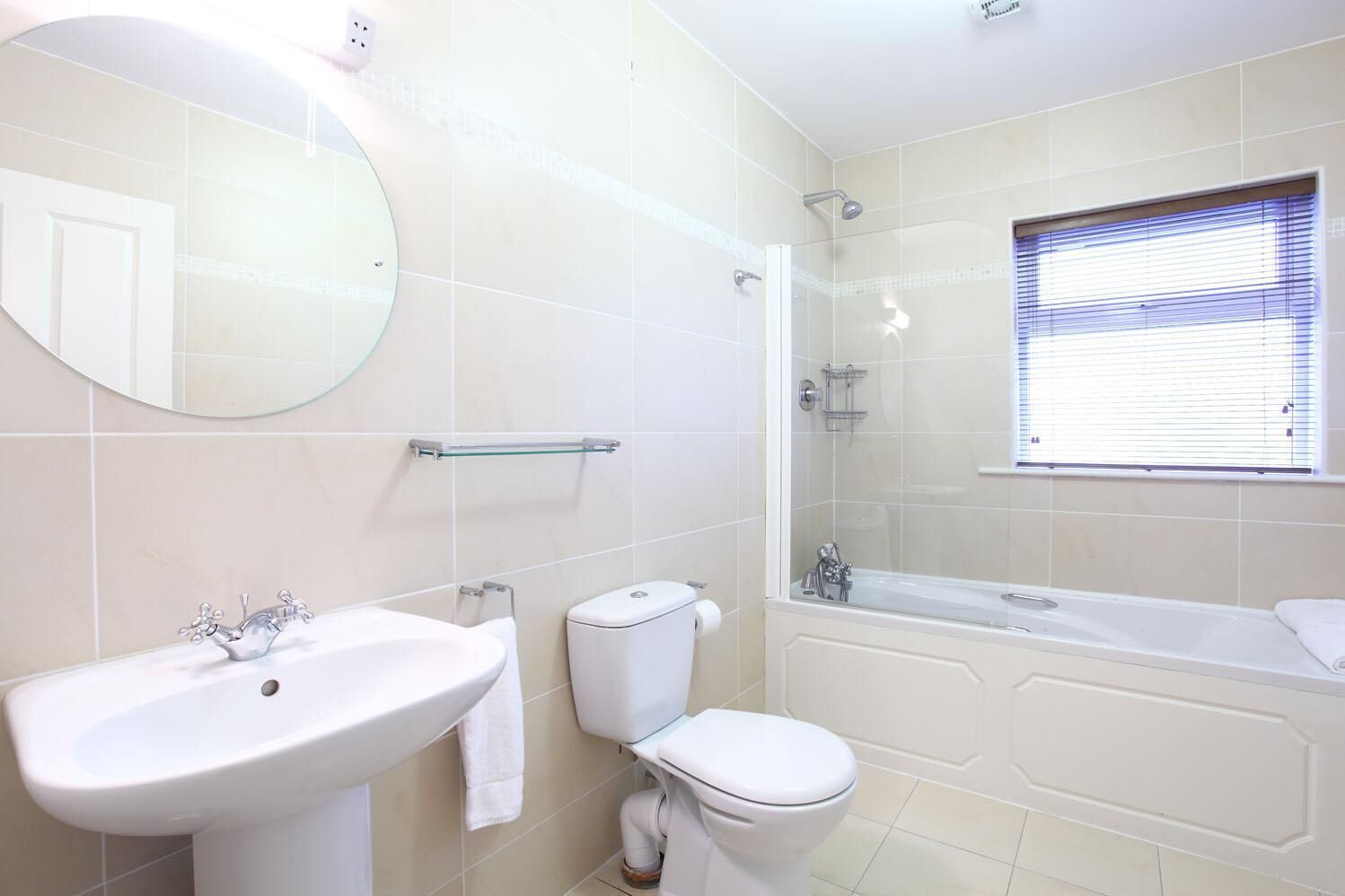 Un baño con lavamanos, inodoro y bañera.