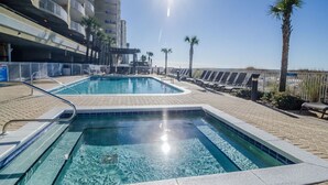 Une piscine offrant une vue ensoleillée sur une plage et des palmiers.