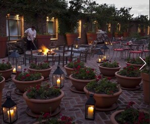 An outdoor patio area with terracotta planters, wooden chairs, and tables. - Residence Master Suite in Porteño Building (Buenos Aires)