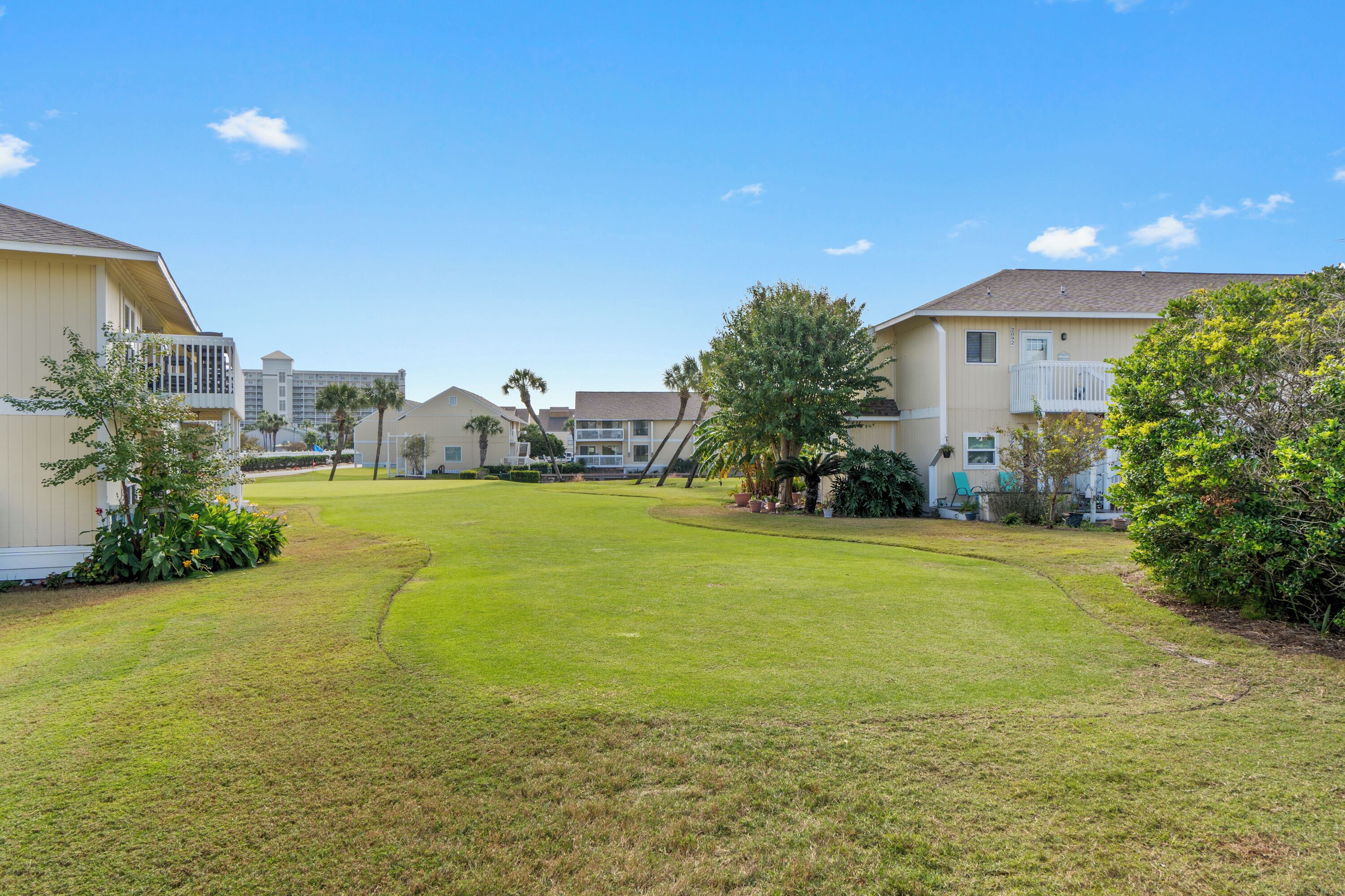 A residential area with houses, a well-maintained lawn, and a clear sky.