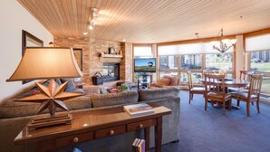 Een gezellige woonkamer met een open haard, comfortabele zitplaatsen en een eethoek met uitzicht op het groen.