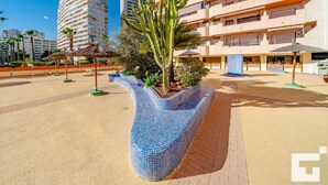 A modern building with a unique blue mosaic planter and palm trees. - Zafiro 35C - Grupo Turis - Calpe, Costa Blanca (Calpe)