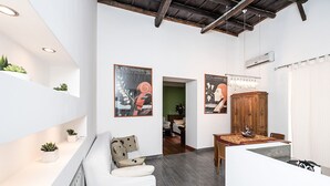 Un interno moderno con un divano bianco, un tavolo in legno e poster alle pareti.