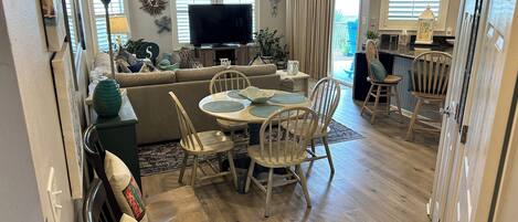 A spacious living area with a large TV, dining table, and comfortable seating.