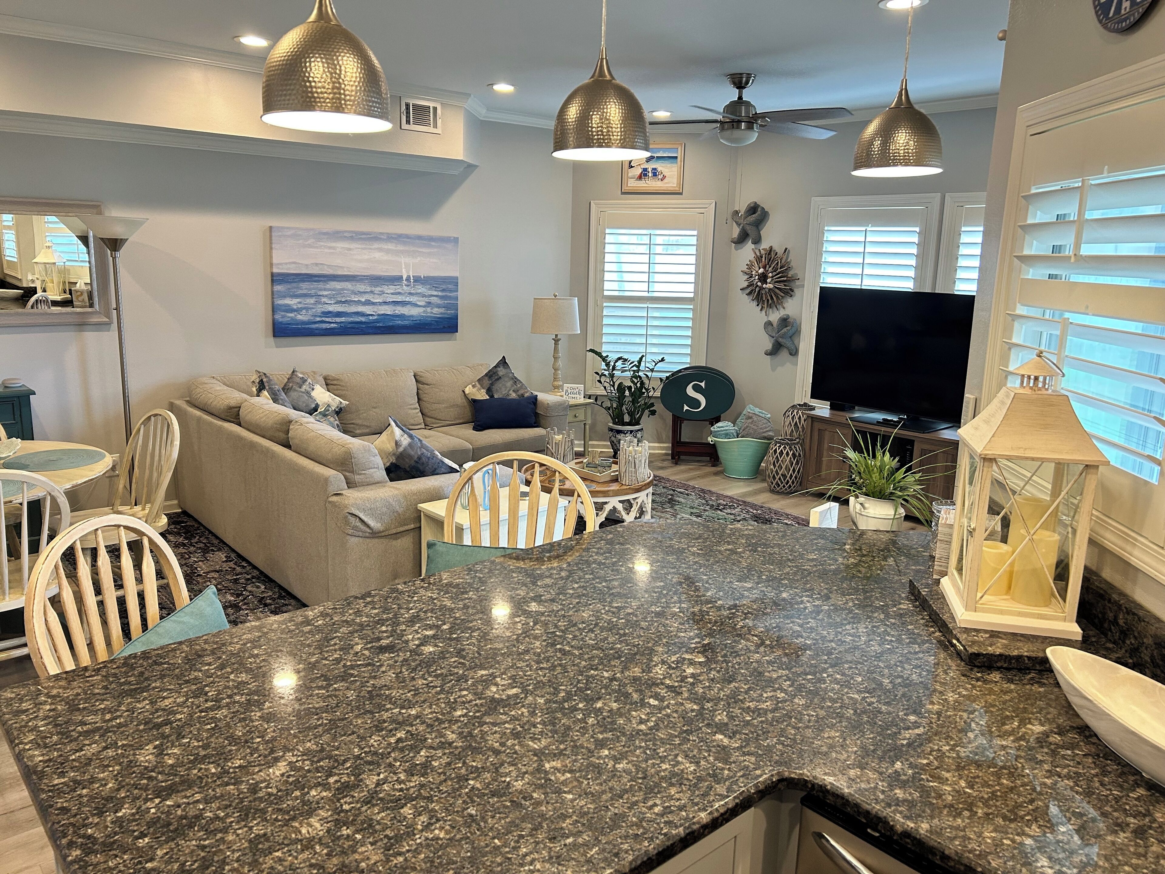 Un salón comedor amplio con una isla central grande, asientos y un televisor.