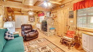 A cozy cabin interior with a stone fireplace, leather armchair, rocking chair, and a green couch. - Large Mountain Creek! Cabin in Tellico Plains (Tellico Plains)