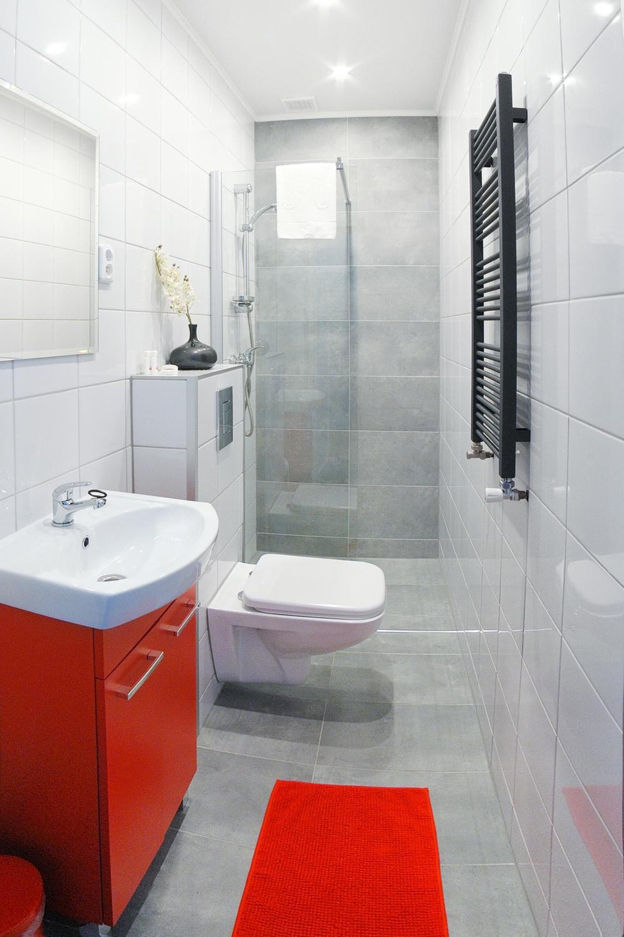 Een moderne badkamer met douche, toilet en wastafel.