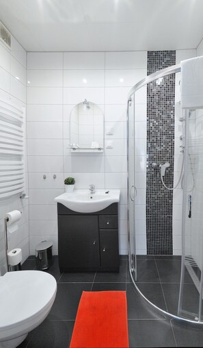 Standaard vierpersoonskamer | Badkamer | Een douche, gratis toiletartikelen, een haardroger, handdoeken