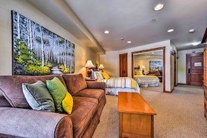 Relax in this stylish living area with a comfortable sofa, coffee table, and large painting.