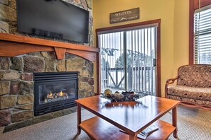 Cozy living area with a fireplace, flat-screen TV, and comfortable sofa.