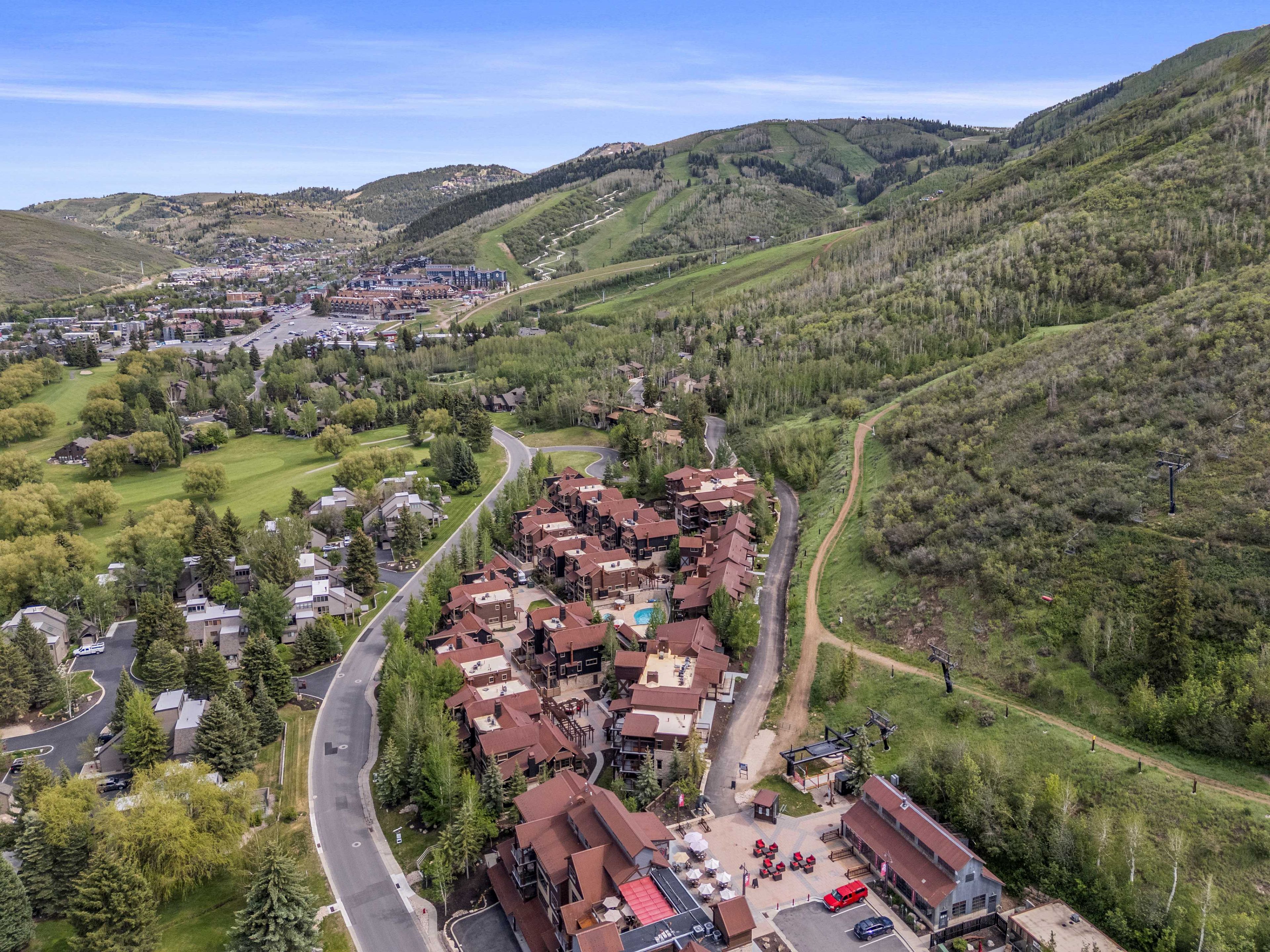 Un quartier résidentiel avec des maisons, une route sinueuse et un paysage vallonné.