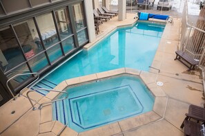 A pool area with multiple seating areas and a small hot tub.