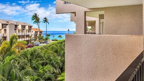 A modern hotel with a balcony overlooking a lush garden and the ocean. - Fun island vibe! Private lanai, Full Kitchen, Flat Screen TV, Air Conditioning, WiFi- Kamaole Sands (KIHEI)