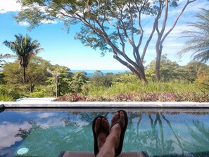 A pool with clear water reflecting trees and a view of the ocean. - Amazing Luxurious Pool House With Big Views and Privacy Best Beach Playa Hermosa (Hermosa de Cobano)