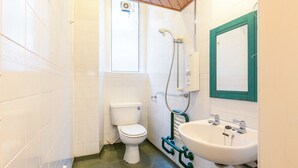 A small bathroom with a toilet, a shower, and a sink.