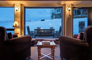 Relax in this inviting seating area with a serene view of the snow-covered landscape.