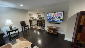 A living room with a flat-screen TV, a coffee table, and a rug. - SUPER UPSCALE RANCH! (Mentor)