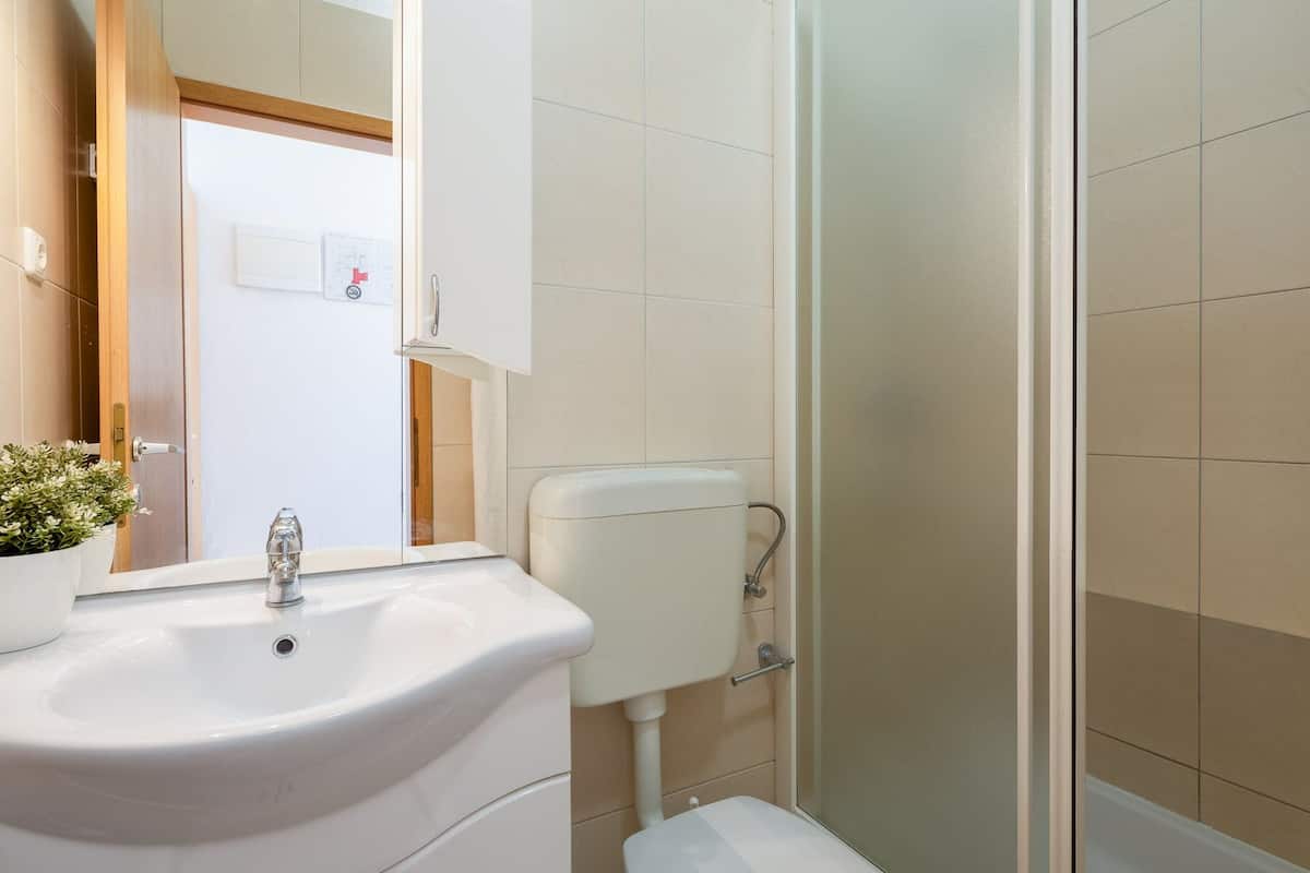 A modern bathroom with a sink, toilet, and shower.