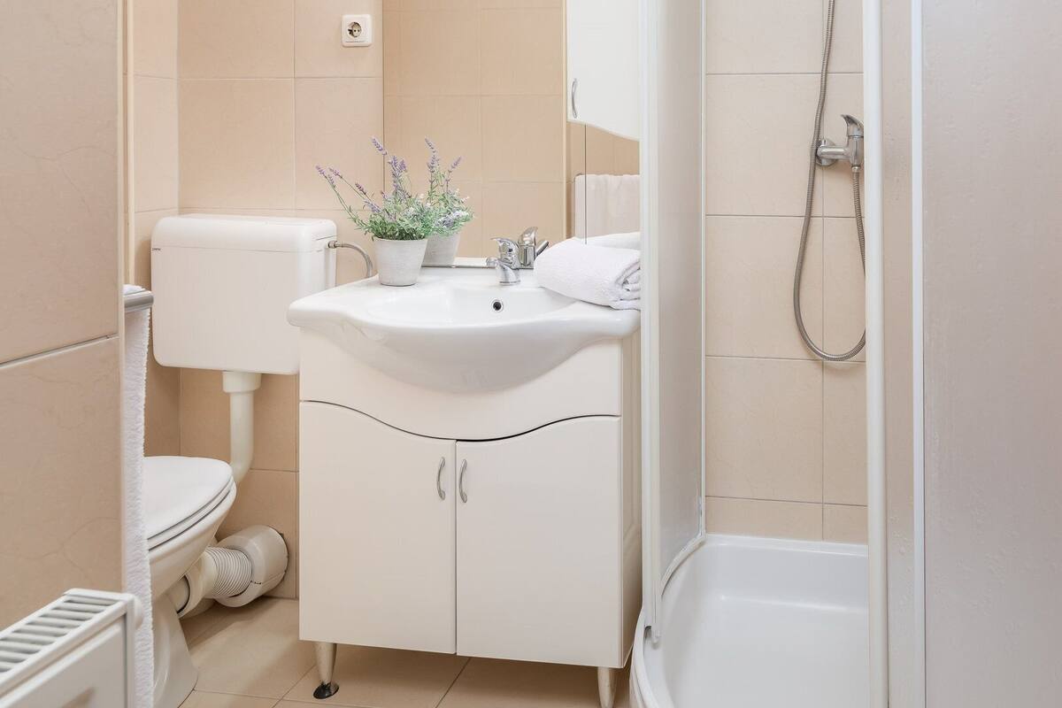 A bathroom with a toilet, sink, and shower.