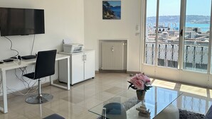 Una sala de estar moderna con un televisor de pantalla plana, un escritorio y una zona de estar acogedora.