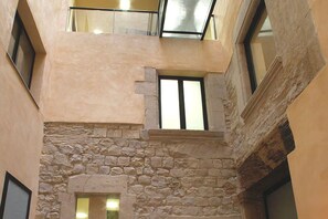 A building with a stone facade, multiple windows, and a balcony. - Charming Old Town Flat Carders with Balcony (Barcelona)