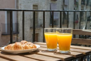 A wooden table with a plate of croissants and two glasses of orange juice. - Charming Old Town Flat Carders with Balcony (Barcelona)