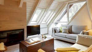 Ett mysigt vardagsrum med en öppen spis, en soffa och ett soffbord.