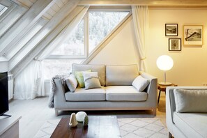 A cozy living room with a sofa, a coffee table, and a lamp.
