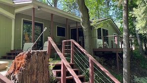 A cabin with a porch, wooden stairs, and a view of the surrounding forest. - Relaxing cozy cabin on beautiful Pere Marquette River - Recently Renovated!! (Branch)