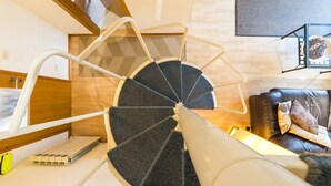 Et moderne trappehus med spiraltrappe, der fører til en etage ovenover.