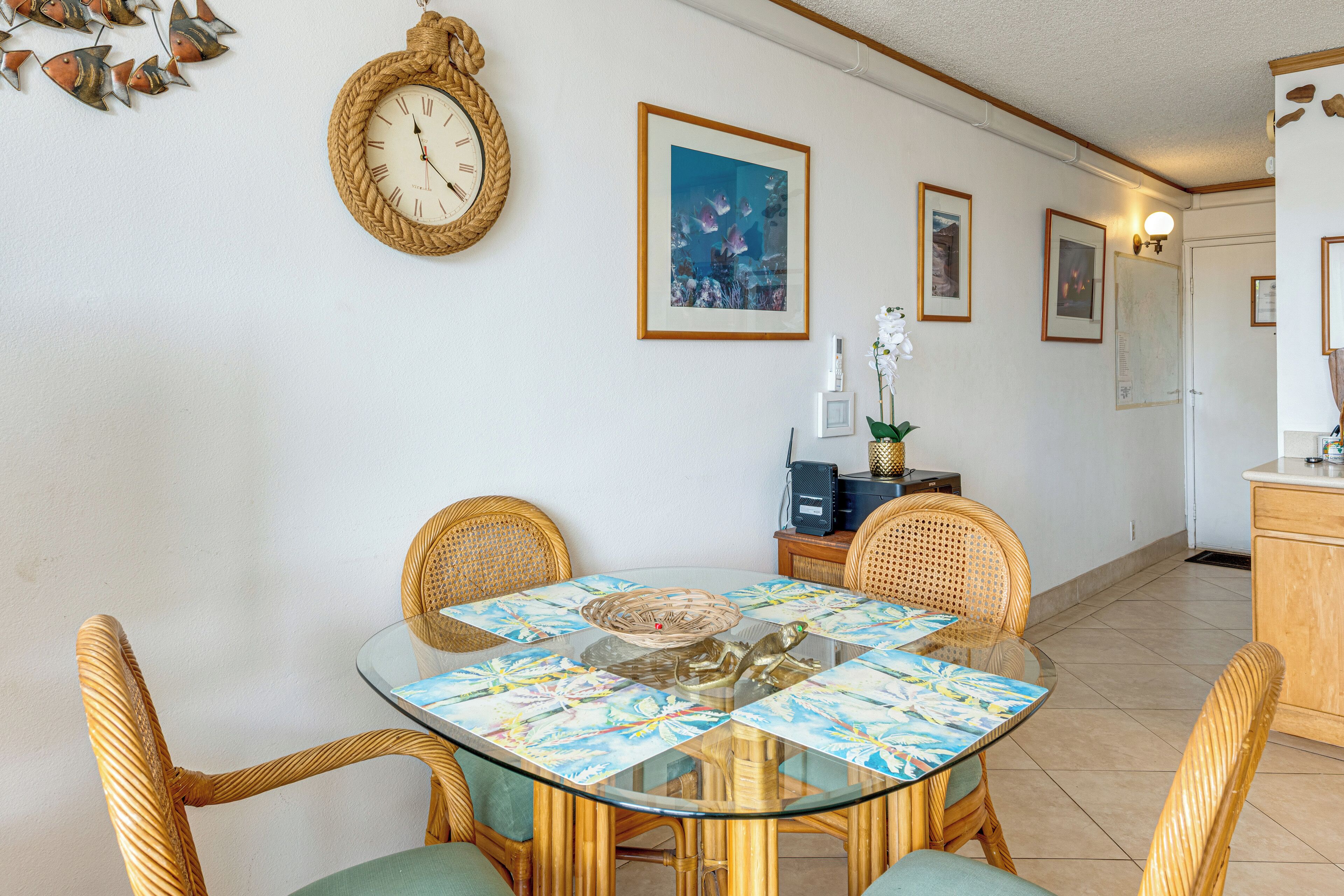 A dining area with a glass table, wicker chairs, and a clock on the wall.