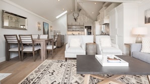 Una sala de estar amplia con comedor, cocina y un espejo grande.