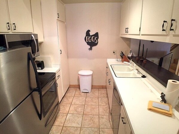 Compact kitchen with modern amenities, featuring a refrigerator, oven, and sink.
