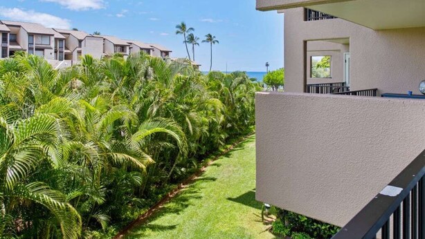 A modern hotel with a balcony overlooking a well-maintained garden and a view of the ocean. - Open-Style Condo w/Chic Kitchen+Dining Area, WiFi, Lanai–Kamaole Sands 9206 (KIHEI)