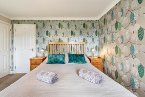 Une chambre à coucher avec un lit, deux tables de chevet et une porte.