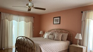 A bedroom with a bed, nightstands, a ceiling fan, and a framed picture on the wall. - Beautiful Home With Heated Pool In A Nice Neighborhood (Spring Hill)
