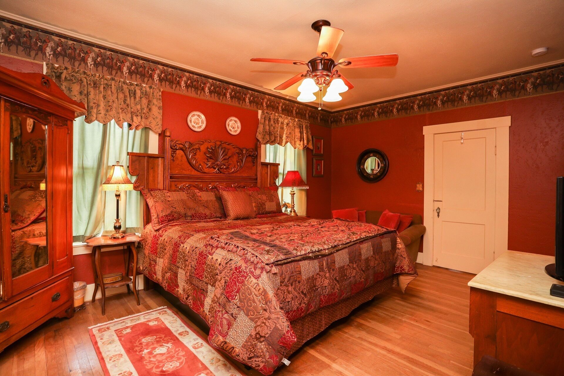 Un dormitorio tradicional con una cama grande, muebles de madera y decoración clásica.