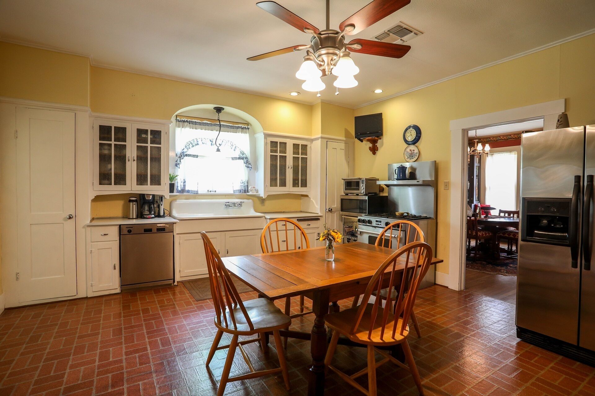 Una cocina con una mesa de comedor, sillas, un refrigerador y un ventilador de techo.