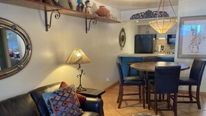 A living room with a leather sofa, a coffee table, and a dining area with chairs and a table. - Beautiful Southwest Style Old Town Scottsdale, Ground Level Condo (Scottsdale)