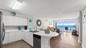 Cocina moderna con armarios blancos, lavavajillas y una isla grande.