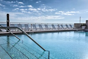 A swimming pool with clear water, a metal ladder, and sun loungers along the edge. - Oceanfront Daytona Beach Club Studio w/ Balcony! (Daytona Beach)