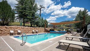 A swimming pool with lounge chairs and a stone wall. - W3533 | Vaulted Ceilings | Nice Views | Winter Shuttle | Pool | Hot Tub (Steamboat Springs)