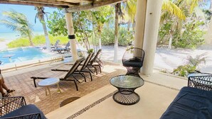A covered outdoor area with lounge chairs, a pool, and tropical vegetation. - Entire House on the Seashore in Chicxulub Puerto, Yuc, Riviera Yucateca Mex (Chicxulub)