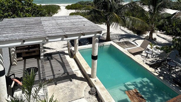 A pool area with a view of the beach, lounge chairs, and palm trees. - Entire House on the Seashore in Chicxulub Puerto, Yuc, Riviera Yucateca Mex (Chicxulub)