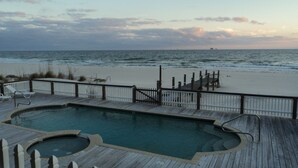 A wooden deck with a pool, overlooking a beach and the ocean. - Reserve now. Beautiful pool and ocean. Easy social distancing. Huge pool deck. <br> (Fort Morgan)