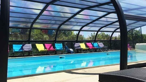 A covered swimming pool with lounge chairs and a clear view of the pool area. - A 1 bedroom cottage that sleeps up to 4 with heated covered pool (Henansal)