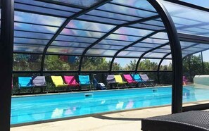 Una piscina techada con sillas de descanso y vista despejada al área de la piscina.